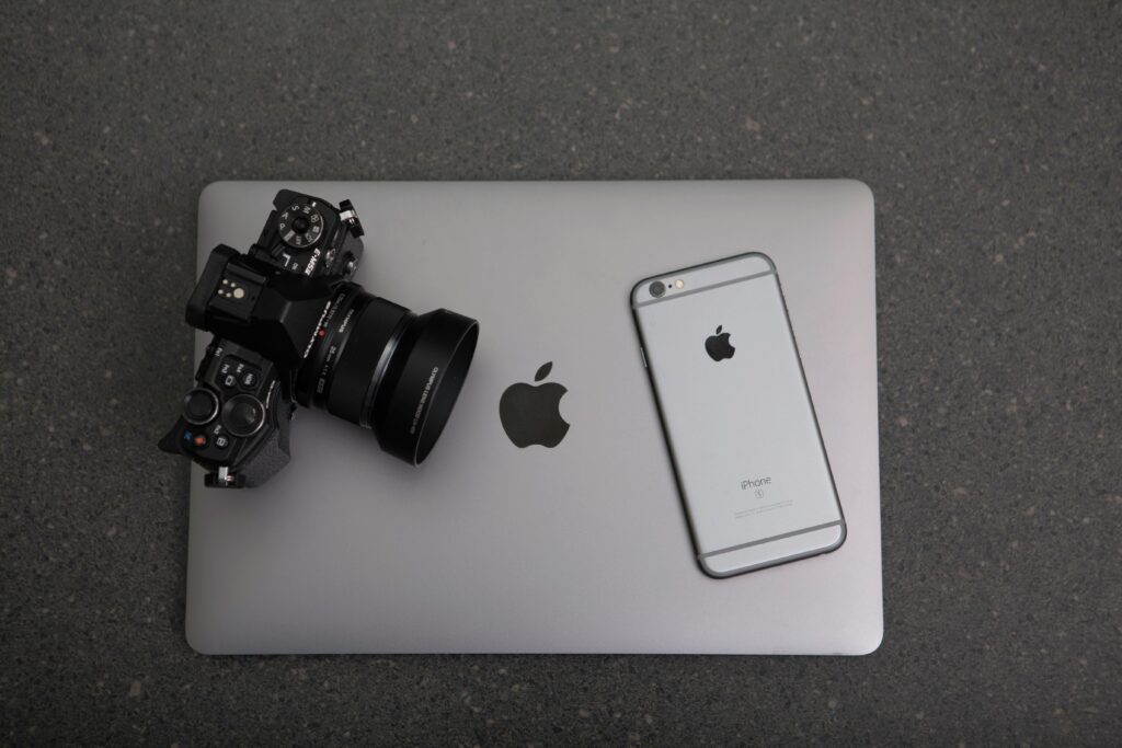 pexels-photo-306763-306763 High-angle shot of DSLR camera, MacBook, and iPhone on textured surface, showcasing modern technology essentials.