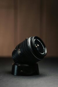 Close-up of a DSLR camera lens on a stand, highlighting its mechanics and design.
