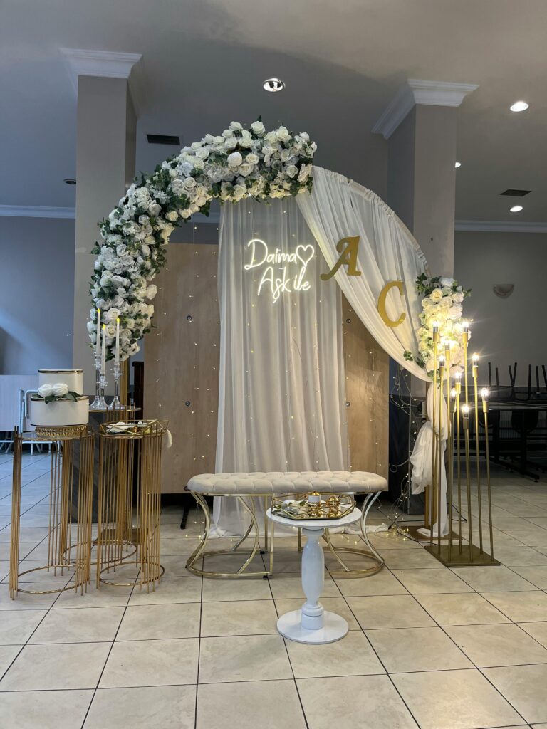 Beautifully decorated wedding arch with flowers and elegant details indoors.
